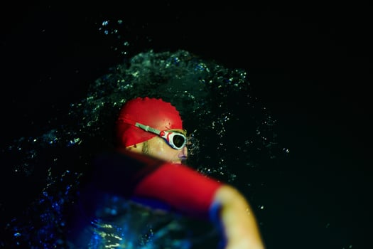 Authentic triathlete swimmer having a break during hard training on night neon gel light photo