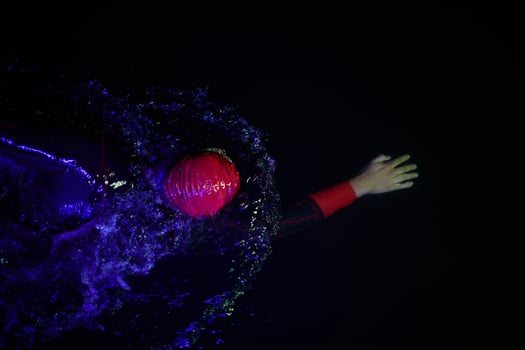 Authentic triathlete swimmer having a break during hard training on night neon gel light photo