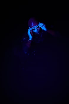 Authentic triathlete swimmer having a break during hard training on night neon gel light photo