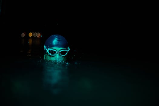 Authentic triathlete swimmer having a break during hard training on night neon gel light photo