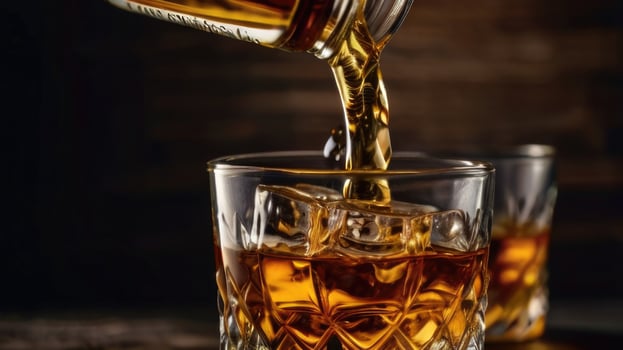 whiskey is poured into a glass photo