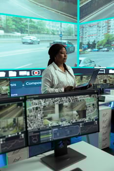 African american leader reviewing traffic data collected from surveillance, instructing her employees team to monitor infrastructure by using CCTV cameras. Government public safety agency. photo