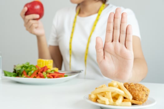 Beauty slim female body confuse French fries. Woman in restaurant achieves weight loss goal for healthy life, crazy about thinness, thin waist, nutritionist. Diet, body shape. photo