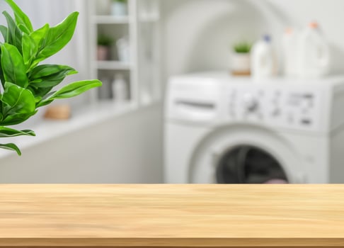 Wood table for display products and blurred laundry room with green plants photo