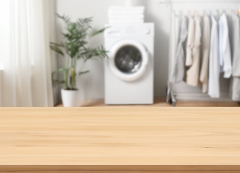 Wood table for display products on background of blurred laundry room photo