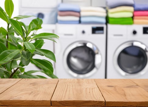 Wood table for display products on blurred laundry room and green plants photo
