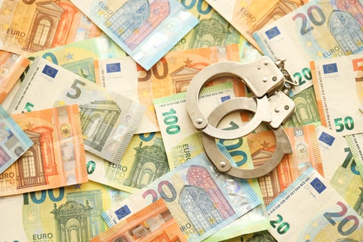 Many European euro money bills and handcuffs. Lot of banknotes of European union currency and cuffs photo