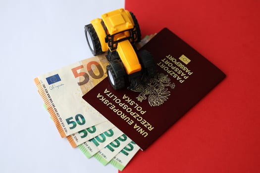 Red polish passport and yellow tractor on euro money and smooth red and white flag of Poland photo