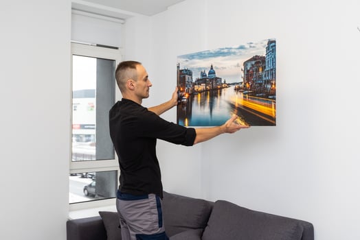 repairman master holds a photo canvas