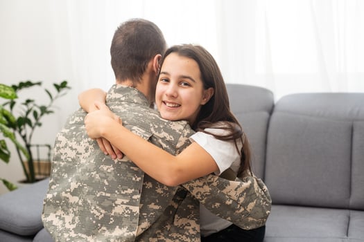 Military dad hugging his daughter photo