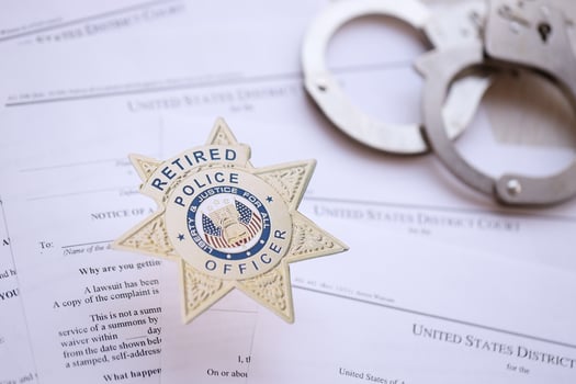 KYIV, UKRAINE - MARCH 9, 2024 US Retired Police Officer badge with handcuffs on many US District Court warrants and complaints photo