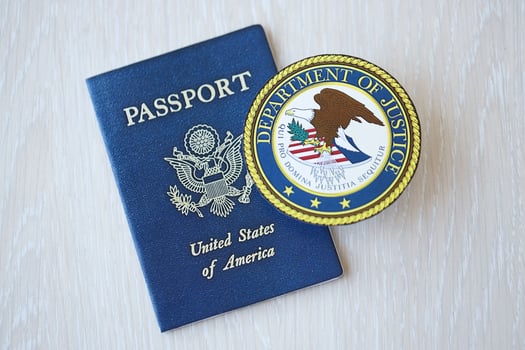 KYIV, UKRAINE - MARCH 9, 2024 US Department of Justice seal and United States passport on wooden table photo