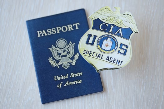 KYIV, UKRAINE - MARCH 9, 2024 US CIA Central Intelligence Agency badge and United States passport on wooden table photo