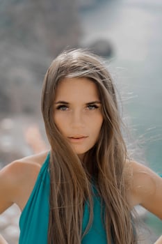 Woman sea green dress. Portrait of a happy woman with long hair in a long mint dress posing on a beach with calm sea bokeh lights on sunny day. Girl on the nature on blue sky background. photo