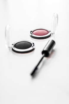 Eyeshadows, black liner and mascara on marble background, eye shadows cosmetics as glamour make-up products for luxury beauty brand, holiday flatlay design photo