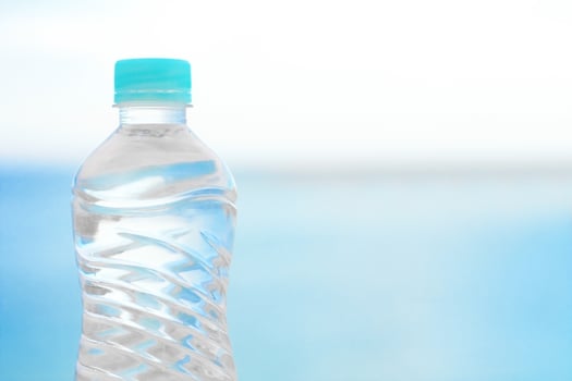 bottle of water on the beach - drinks, summertime and environment concept photo