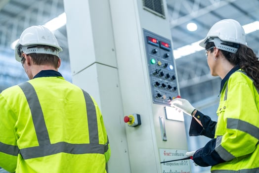 Male and female engineers in neat work clothes prepare and control the production system of large modern machines in a factory producing industrial technology products. photo