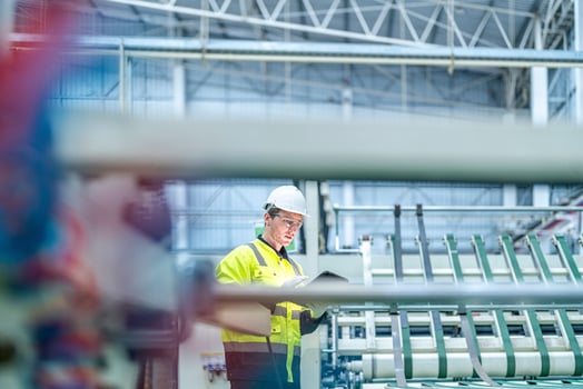 Male and female engineers in neat work clothes prepare and control the production system of large modern machines in a factory producing industrial technology products. photo