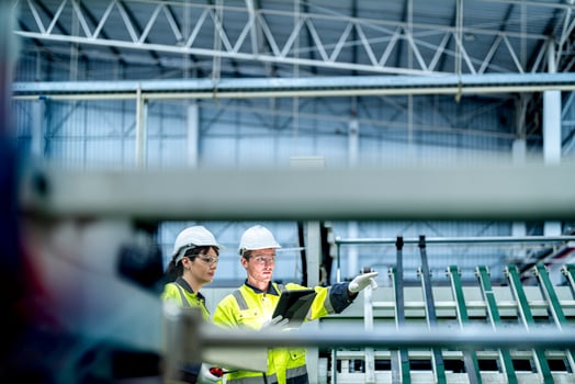Male and female engineers in neat work clothes prepare and control the production system of large modern machines in a factory producing industrial technology products. photo