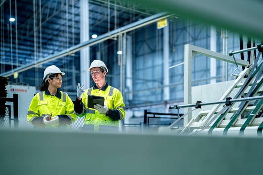 Male and female engineers in neat work clothes prepare and control the production system of large modern machines in a factory producing industrial technology products. photo