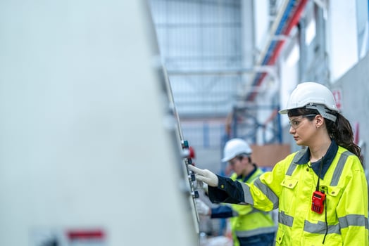 Male and female engineers in neat work clothes prepare and control the production system of large modern machines in a factory producing industrial technology products. photo