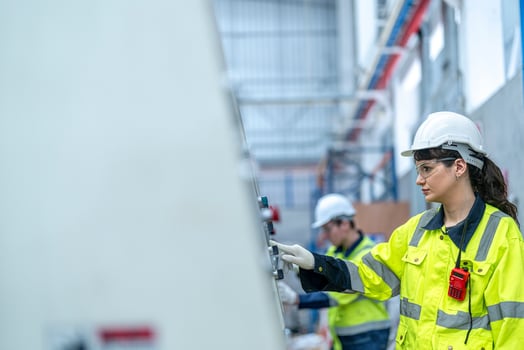 Male and female engineers in neat work clothes prepare and control the production system of large modern machines in a factory producing industrial technology products. photo