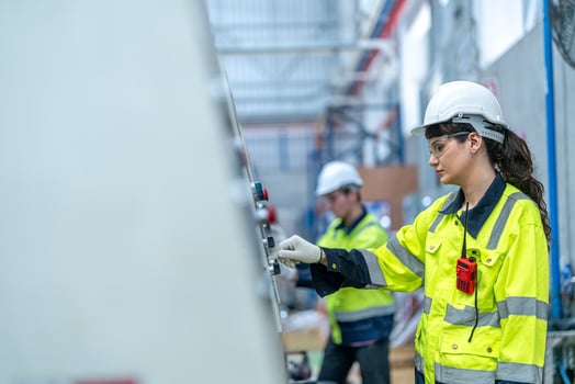 Male and female engineers in neat work clothes prepare and control the production system of large modern machines in a factory producing industrial technology products. photo