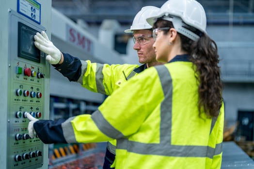 Male and female engineers in neat work clothes prepare and control the production system of large modern machines in a factory producing industrial technology products. photo