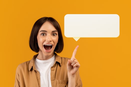 Wow, eureka. Emotional young woman having great idea, finding inspiration or solution to problem, posing with open mouth over yellow background, pointing at blank communication balloon, sharing news photo