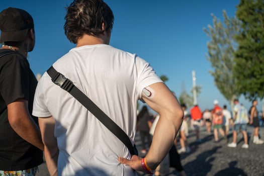 Male tourist with glucose monitoring system sensor on arm in city photo