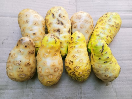 Ripe noni fruit on a cardboard with a close-up horizontal view photo