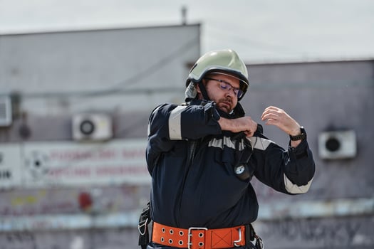 A firefighter dons the essential components of their professional gear, embodying resilience, commitment, and readiness as they gear up for a hazardous firefighting mission, a testament to their photo