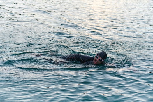A professional triathlete trains with unwavering dedication for an upcoming competition at a lake, emanating a sense of athleticism and profound commitment to excellence. photo