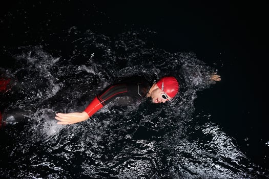 A determined professional triathlete undergoes rigorous night time training in cold waters, showcasing dedication and resilience in preparation for an upcoming triathlon swim competition photo