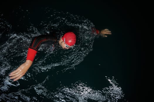A determined professional triathlete undergoes rigorous night time training in cold waters, showcasing dedication and resilience in preparation for an upcoming triathlon swim competition photo