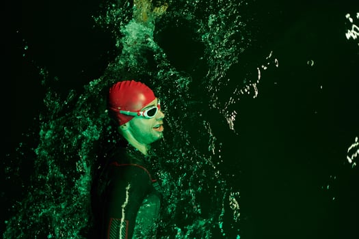 Authentic triathlete swimmer having a break during hard training on night neon gel light photo