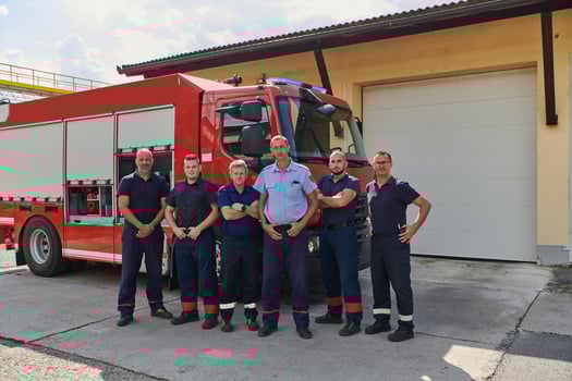 A skilled and dedicated professional firefighting team proudly poses in front of their state of the art firetruck, showcasing their modern equipment and commitment to ensuring public safety. photo