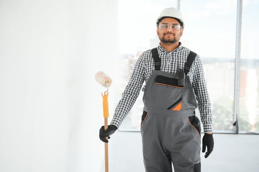 Indian Painter painting the office wall with roller paint photo