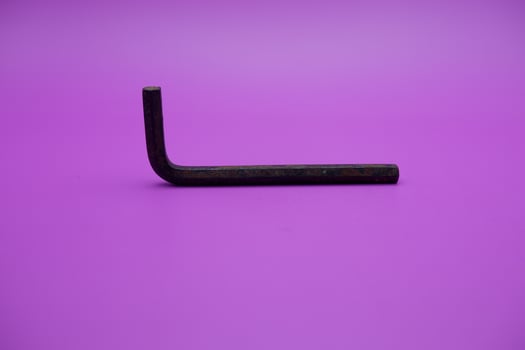 Allen key isolated purple background. a black L key. photo