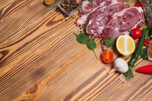 Raw pork meat on wooden cutting board at kitchen table for cooking pork steak roasted or grilled with ingredients herb and spices , Fresh pork. photo