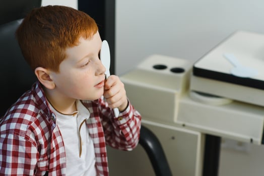 Child at eye sight test. Little kid selecting glasses at optician store. Eyesight measurement for school kids. Eye wear for children. Doctor performing eye check. Boy with spectacles at letter chart photo