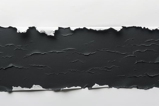 Ripped black paper in flat lay arrangement on clean white background. Torn banner concept photo