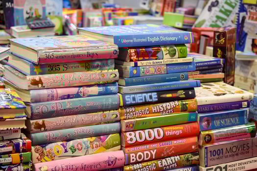 New Delhi, India, May 17 2024 - Variety of Books on shelf inside a book-stall at Delhi International Book Fair, Selection of books on display in Annual Book Fair at Bharat Mandapam complex photo