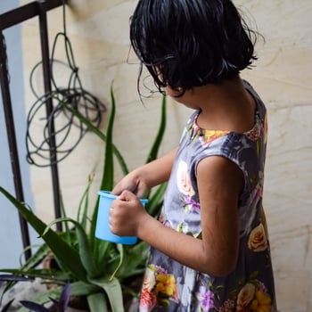 Cute 5 year old Asian little girl is watering the plant in the pots located at house balcony, Love of sweet little girl for the mother nature during watering into plants, Kid Planting photo