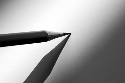 Pencil holding to write on the paper in shadow photo