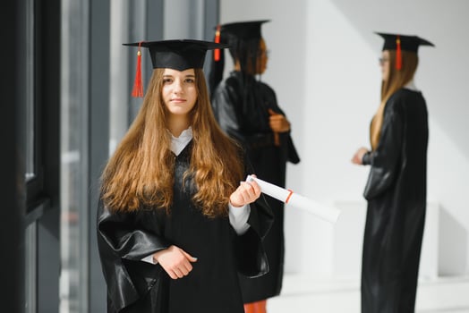 Pretty female college graduate at graduation with classmates photo