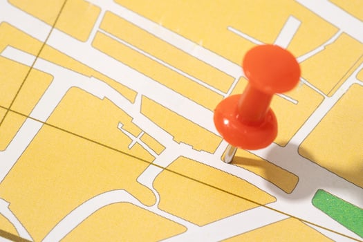 Thumbtack on a paper city map. Map location concept photo