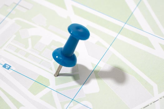 Thumbtack on a paper city map. Map location concept photo