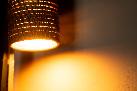 Woven lampshade with warm light bulb photo