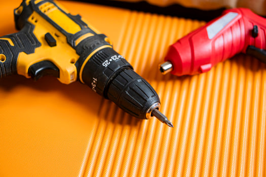 Cordless drill and screwdriver on orange surface photo
